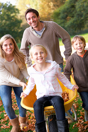 Family pushing a girl in a wheelbarrow